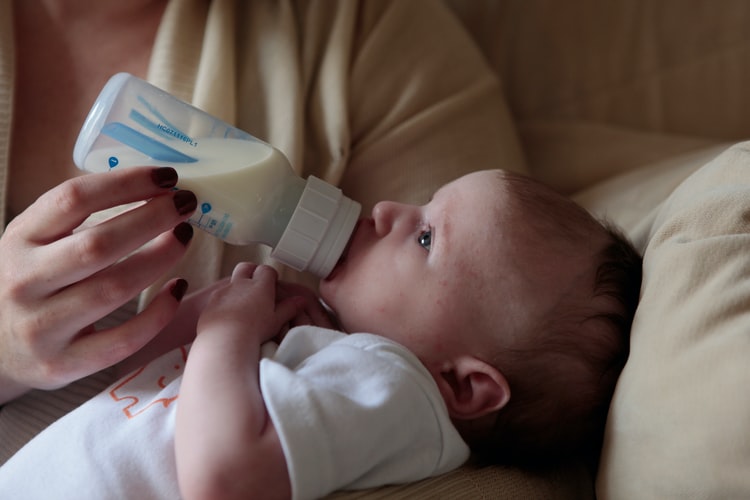 抱っこされてミルクを飲む赤ちゃんの画像